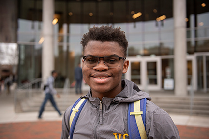 Student smiles at the camera on the Compass